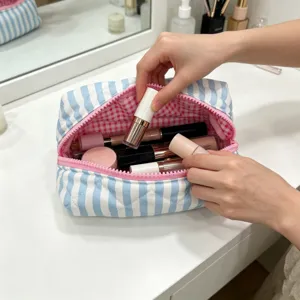 Detail shot of striped makeup bag showing large capacity and pink checkered lining