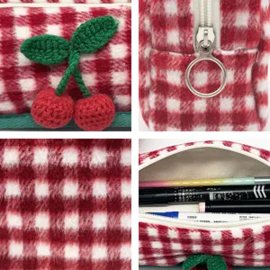 Detailed view of red gingham pencil case with crochet cherry decoration and fuzzy texture