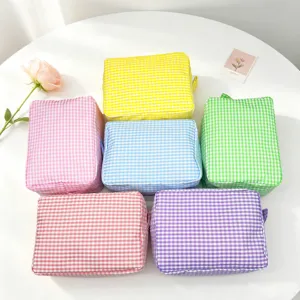 Collection of various colorful seersucker checkered makeup bags for travel and storage