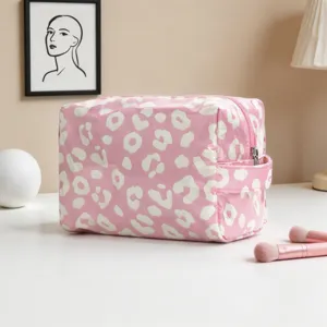 Vista detallada del neceser rosa con estampado de leopardo sobre una mesa blanca