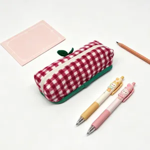Detailed view of a red and white plaid wool pencil case featuring cute stationery props