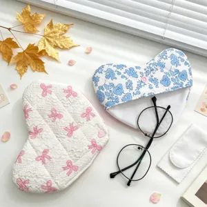 Vista detallada de una linda funda para gafas de tela en forma de corazón con flores y lazos