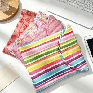 Vista detallada de fundas acolchadas para portátil con varios estampados florali y rayas