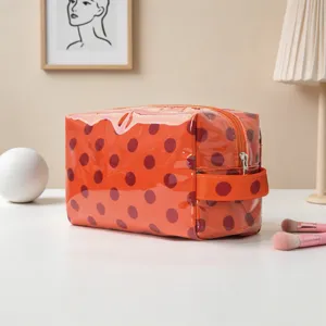 Bolsa de cosméticos con lunares naranjas de gran capacidad en un entorno minimalista