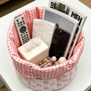 Desktop fabric storage basket with pink bow pattern organizing various household items