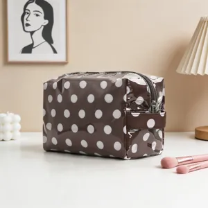 Vista detallada de la bolsa de maquillaje marrón con lunares en un tocador moderno.