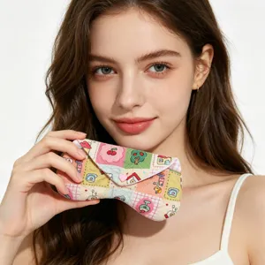 Primer plano de una funda para gafas de tela con motivos coloridos sostenida por una modelo
