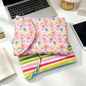 Fundas acolchadas para portátil con flores y rayas de arcoíris en un escritorio limpio