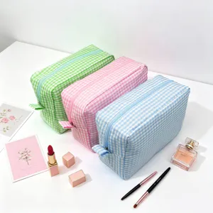 Set of three large gingham seersucker cosmetic bags in pastel green, pink, and blue.
