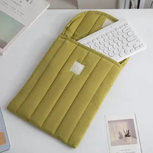 Detalle de funda acolchada verde oliva para portátil con un teclado blanco en el bolsillo