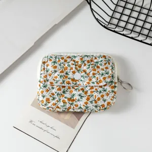 Vista macro de una mini bolsa de almacenamiento acolchada con motivo floral naranja