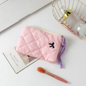Vista detallata de un mini neceser de maquillaje rosa acolchado para lápiz labial