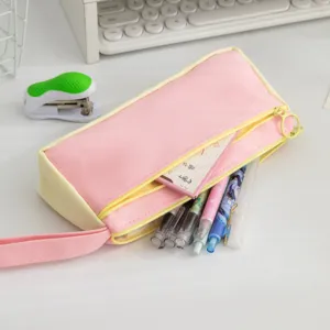 Detail view of a pink and yellow colorblock pencil case with various pens inside.