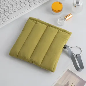 Vista detallada de la funda acolchada verde oliva para portátil de 13 pulgadas en un escritorio.