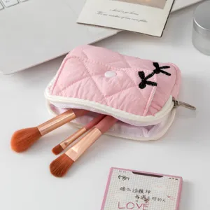 Primer plano del mini estuche acolchado rosa con brochas de maquillaje