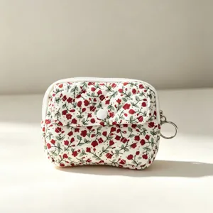 Primer plano de un mini estuche acolchado con flores y cremallera para auriculares