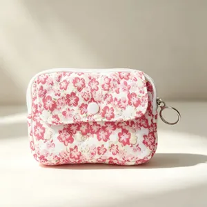 Primer plano de bolsa floral acolchada con botón a presión y llavero