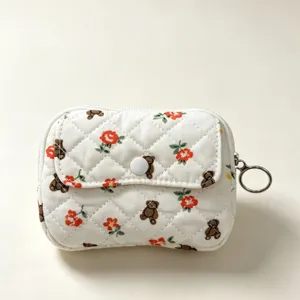 Vista detallada del mini estuche acolchado blanco para auriculares con ositos y flores