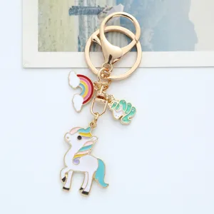 Detailed view of a golden unicorn keychain with colorful enamel rainbow charm