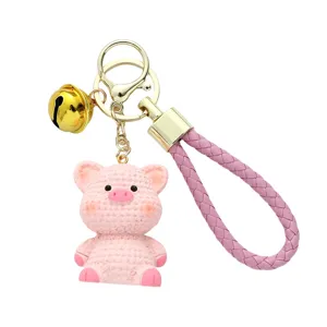 Cute pink resin pig keychain featuring knitted texture with braided strap and bell