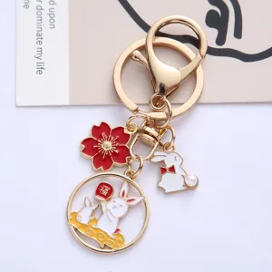 Detailed view of cute cartoon rabbit and red flower alloy keychain charms