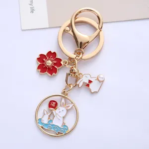 Close-up of cute enamel rabbit and sakura charms on a gold alloy keychain