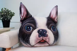 Cojín decorativo 3D con forma de perro colocado en un sofá de una sala de estar.