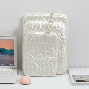 Juego de tres fundas para portátil blancas acolchadas con diseño de corazones para iPad.