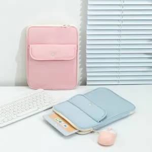 Fundas para tableta rosa y azul pastel con bolsillo frontal en escritorio blanco y accesorios