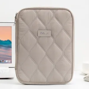 Detailed view of the quilted 11-inch tablet sleeve in a minimalist office desk setting