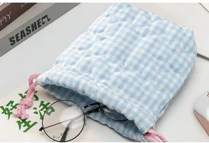 Gros plan d'une pochette matelassée à cordon bleu vichy avec cordons roses pour appareil
