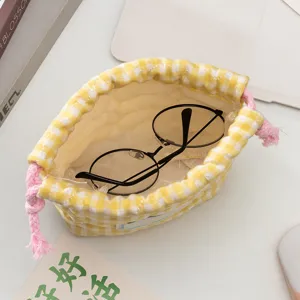 Détail d'un sac de rangement à cordon à carreaux jaunes matelassé avec des lunettes