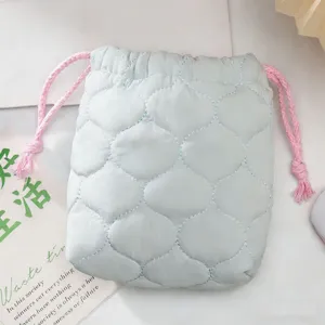 Gros plan d'un sac d'appareil photo matelassé bleu clair avec cordon de serrage rose