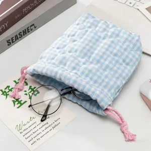 Gros plan d'un sac à cordon matelassé à carreaux bleu clair avec une texture en coton doux