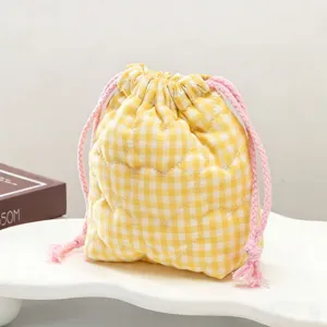 Détail du sac à cordon en vichy jaune avec motif de cœur matelassé pour l'appareil photo.