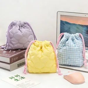 Gros plan de trois pochettes matelassées colorées pour appareils photo sur un bureau moderne