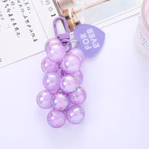 Close-up of a purple iridescent grape cluster keychain with a FOR EVER heart tag.