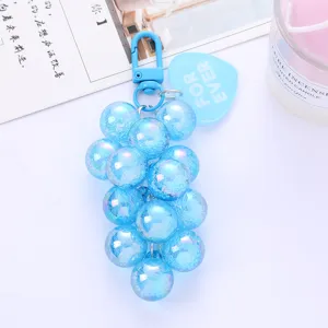 Macro view of a blue iridescent grape keychain with a FOR EVER heart tag pendant