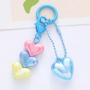 Detailed macro shot of colorful acrylic heart pendants on a light blue keychain accessory