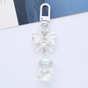 Detail showing the iridescent acrylic bear and bow on this cute white metal keychain