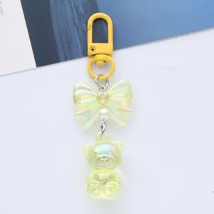 Close-up detail of a dreamy iridescent acrylic bear keychain featuring a gradient bow