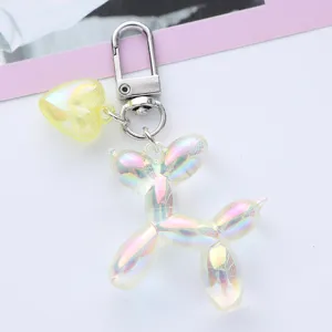 Macro detail of a trendy iridescent balloon dog keychain with yellow heart charm.