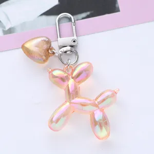 Close-up detail of a pink iridescent balloon dog keychain featuring a gold heart charm