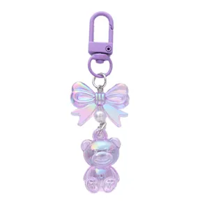 Iridescent purple acrylic bear keychain featuring a holographic bowknot and pearl charm