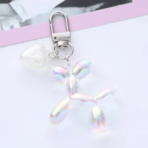 Macro view of iridescent balloon dog keychain with a pearlescent heart charm.