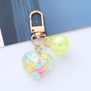 Close-up of colorful heart acrylic keychain with faceted pendant and gold clasp