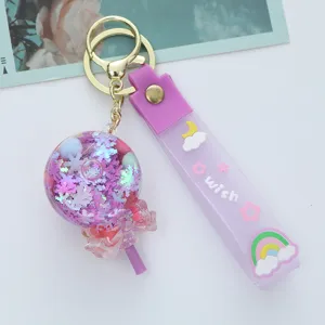 Close-up of a purple acrylic oil-filled lollipop keychain with sparkling sequins