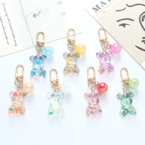 Close-up of cute acrylic colorful bear keychains featuring glitter charms and gold clasps