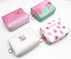 Detalle de cuatro bolsas de cosméticos de fresa impermeables con cremalleras doradas