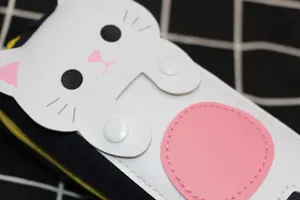 Gros plan sur une broderie de chat de dessin animé sur une trousse en toile durable